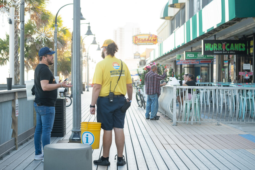 Gold Cap Ambassador Assisting Resident on Boardwalk